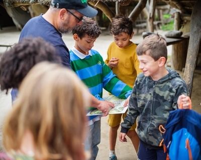 Kinderen rondom een kaart bij een avontuurlijk kinderfeestje van VONK.