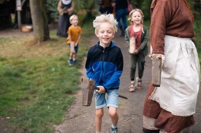Groep kinderen speelt stokpaardje rijden