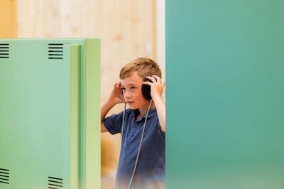 Jonge bezoeker luistert in de Werkplaats van Verbeelding.